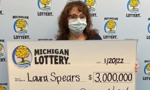 Michigan lottery winner with $3 million check.