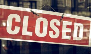 Vintage,Looking,Closed,Sign,In,A,Shop,Showroom,With,Reflections