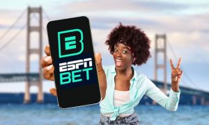 Image of woman holding up phone with logo of ESPN Bet, which, along with Hollywood Casino Online, launched Nov. 14 in Michigan
