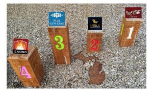 Wooden playground pillars numbered one through four with the logos of Michigan's four tribal online casinos on top to signify the ranking of Michigan's tribal online casinos.