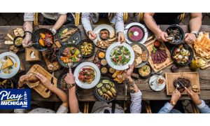Multiple people sitting around a table able piled high with various kinds of food. The Soaring Eagle and Odawa Petoskey casinos have opened new dining options