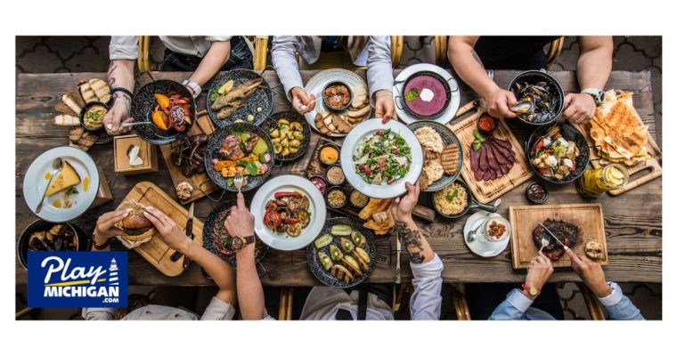 Multiple people sitting around a table able piled high with various kinds of food. The Soaring Eagle and Odawa Petoskey casinos have opened new dining options