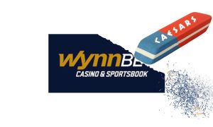 An eraser with the Caesars logo on it is erasing part of the WynnBet casino and sportsbook logo. Caesars has announced that it is acquiring the online casino and sportsbook license of WynnBet in Michigan, pending regulatory approval.