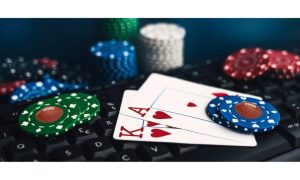 Blackjack hand and chips on a computer keyboard. Some of the chips have a football on them to reflect Caesars Palace adding live dealer football blackjack to its Michigan online casino