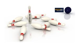 A single bowling pin is still standing. It has Michigan written on it. A bowling ball has the WynnBet logo beside it. Michigan is the only state where a WynnBet online casino is still in business.