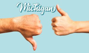 Large thumbs down and thumbs up against a light blue background with the word "Michigan" in 3D script font. Michigan sportsbooks logged $415.8 million in bets in February. That was down sharply from January, but up 16.4% year-over-year.