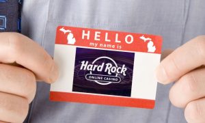 Business man with a "Hello my name is" sticker with the Hard Rock online casino logo on it. Hard Rock online casino and sportsbook has two ways it could come to Michigan: by acquiring BetRivers or the open license left by SI.