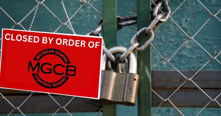 Chain link fenced locked with a chain and large padlock. There is a red sign hanging from the fence reading "Closed By Order Of" with the logo of the Michigan Gaming Control Board. Linos Antonio Kas-Mikha and Robert Jamerson each face four felony charges for allegedly operating an illegal storefront casino in Flint.