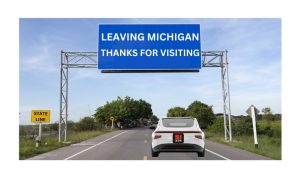 White car with a SI casino license plate driving out of the state of Michigan. The car is passing under a large blue highway sign that reads "Leaving Michigan. Thanks For Visiting." Michigan will lose SI Casino and SI Sportsbook in the future after 888 announced plans to leave the US markets on Wednesday.