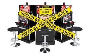 Three slot machines covered in yellow caution tape that reads "Seized by order of MGCB." Last year, the MGCB sent letters to 64 businesses demanding they cease illegal gambling activities. It led to the removal of 167 machines.