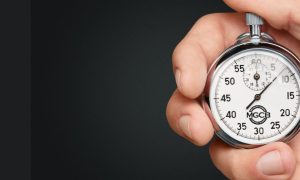 Hand holding a stopwatch with the Michigan Gaming Control Board logo on it. The Michigan Gaming Control Board has sent a memo to gambling operators saying customer complaints about slow payouts are on the rise.