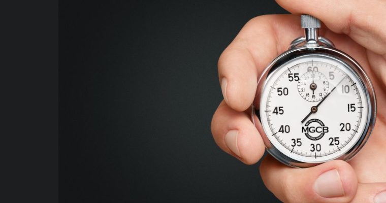 Hand holding a stopwatch with the Michigan Gaming Control Board logo on it. The Michigan Gaming Control Board has sent a memo to gambling operators saying customer complaints about slow payouts are on the rise.