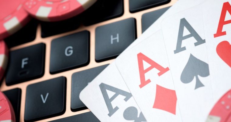 Poker chips and four aces are laid on a computer keyboard to signify online poker. Just in time for the 2024 World Series of Poker, WSOP is expected to launch multi-state poker pools between Michigan, New Jersey and Nevada.