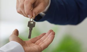 Businessman handing over the keys to another businessman. PENN Entertainment's Hollywood Casino at Greektown in Detroit could have a new owner amid Boyd/Flutter acquisition talks.