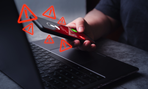 a phone over a laptop computer with warning signs around it