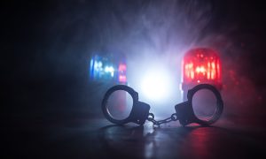 Red and blue police lights, handcuffs, criminal suspect arrested