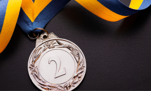 a second-place silver medal laying on a black surface