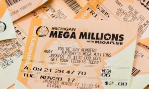 a pile of michigan lottery tickets with a mega millions ticket on top