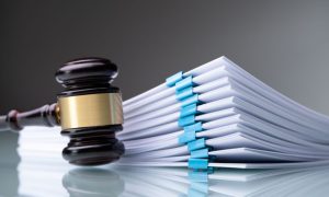 a gavel sitting next to a stack of legal papers