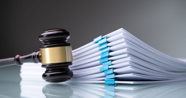 a gavel sitting next to a stack of legal papers