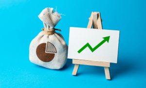 a bag of money sitting next to a chart that shows growth