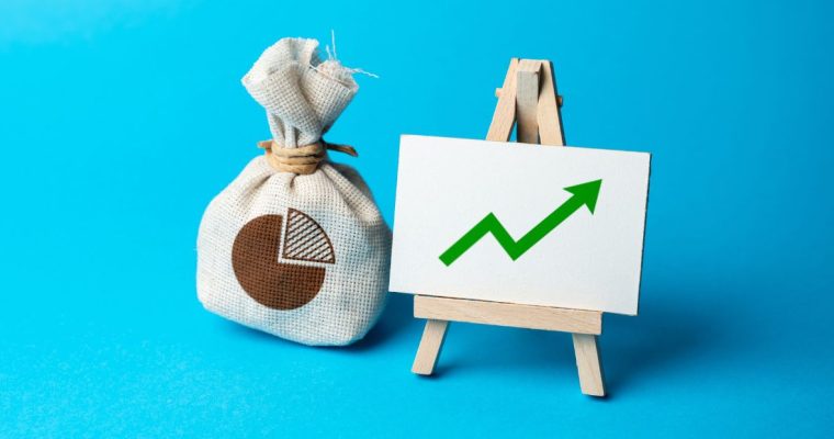a bag of money sitting next to a chart that shows growth