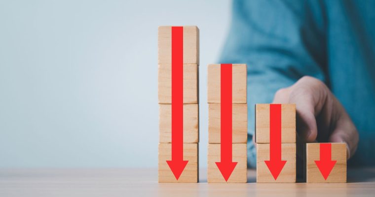 Stack of blocks with red arrows pointing down, illustrating declining casino revenue